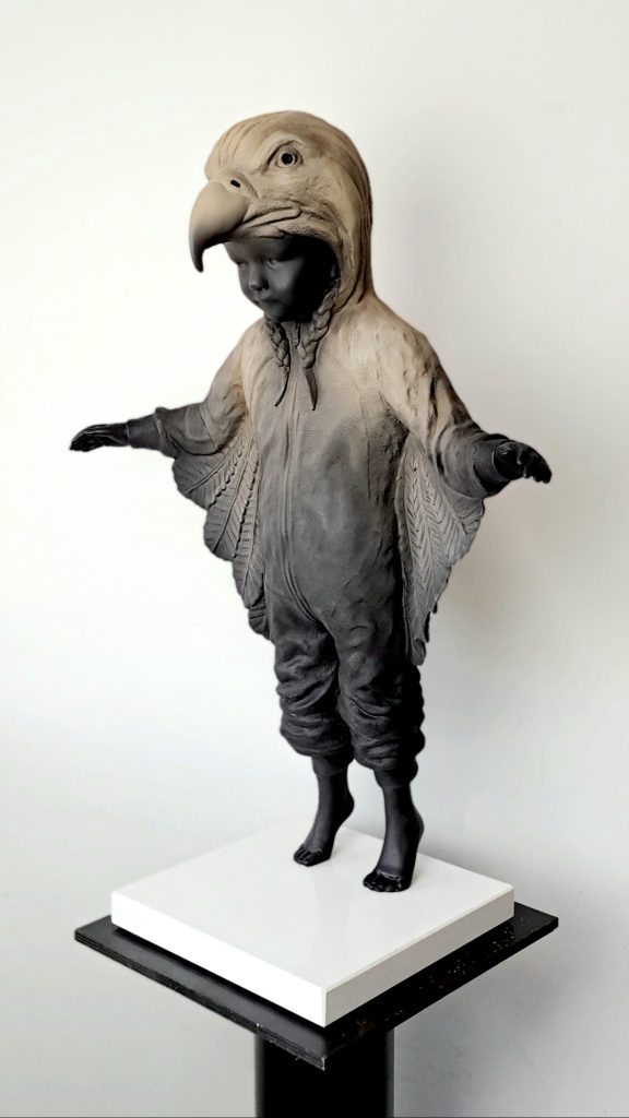 Hannes Verhoeven, "Learning to Fly," marble composite, 60 cm — child in an eagle costume with wings spread