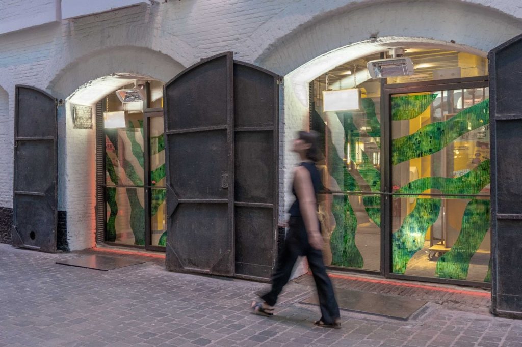 Loumi Le Floc'h, Precious Peels — storefront glazing installation with a green wave pattern in dyed eggplant skin
